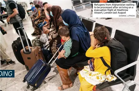  ?? DOMINIC LIPINSKI ?? Refugees from Afghanista­n waiting to be processed after arriving on a evacuation flight at Heathrow Airport, London last August