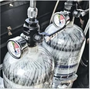  ??  ??  A set of wild carbon fiber nitrous bottles are another nod to extreme weight savings. Dual bottles are used to avoid pressure drops since the Ford uses so much nitrous on every pass.