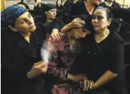  ?? Mohamed El-Shahed / AFP / Getty Images ?? Relatives of some of the 29 Coptic Christians killed in a Cairo ambush grieve Friday during a funeral at Abu Garnous Cathedral in Maghagha, Egypt.