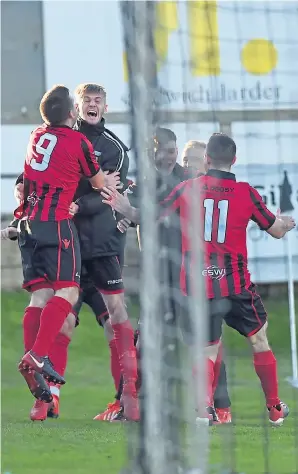  ??  ?? Jubilation: Neil Gauld celebrates with Locos team-mates after making it 2-1