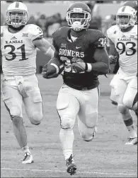  ?? AP/SUE OGROCKI ?? Oklahoma running back Samaje Perine (32) runs toward the end zone en route to one of his five touchdowns during the No. 21 Sooners’ 44-7 victory over the Jayhawks on Saturday in Norman, Okla. Perine also set an NCAA single-game rushing record with 427...