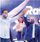  ?? F.E. ?? Danilo Medina levanta la mano de Rafael Paz en un acto en el club San Carlos.