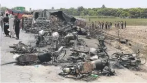  ??  ?? Soldiers stand guard Sunday while rescue workers examine the site of an oil tanker explosion on a highway near Bahawalpur, Pakistan. »to see a gallery go to