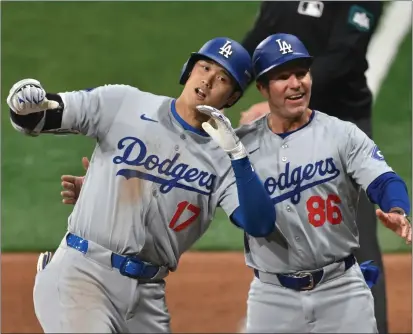  ?? JUNG YEON-JE – AFP VIA GETTY IMAGES ?? The Dodgers’ Shohei Ohtani celebrates with first base coach Clayton Mccullough after hitting an RBI single in the eighth inning Wednesday.