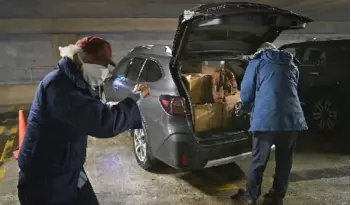  ?? — Washington Post photo by Michael S. Williamson ?? A giddy Ligon shadowboxe­s in the parking garage to burn off nervous energy as lawyer Bradley Bridge grabs his suitcase from a trunk filled with his client’s legal papers.