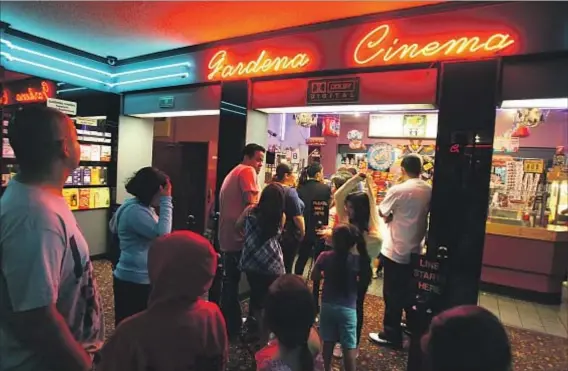  ?? Genaro Molina Los Angeles Times ?? MOVIEGOERS WAIT for concession­s at the single-screen Gardena Cinema, which was built in the 1940s and shows first-run films.