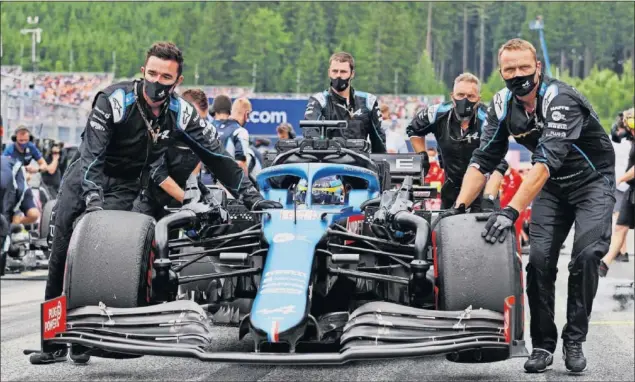  ??  ?? Los mecánicos de Alpine empujan el coche de Fernando Alonso hacia su posición de salida en la parrilla de la carrera del pasado GP de Austria disputado en Red Bull Ring.