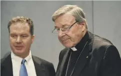  ??  ?? 0 Cardinal George Pell, right, arrives for the press conference with his media ‘minder’, Vatican press office director Greg Burke