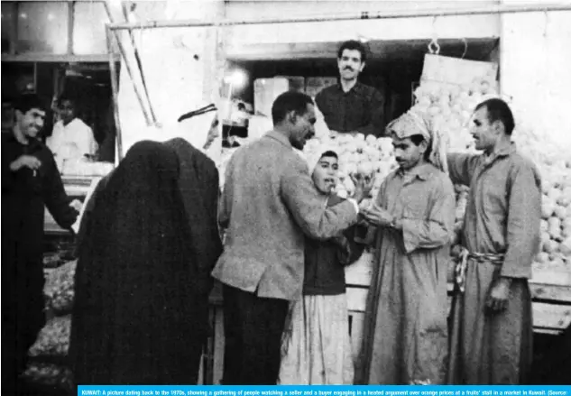  ??  ?? KUWAIT: A picture dating back to the 1970s, showing a gathering of people watching a seller and a buyer engaging in a heated argument over orange prices at a fruits’ stall in a market in Kuwait. (Source: ‘Kuwait Miracle of on the Desert,’ by David Cooke, New York, 1970. Researched by Mohammed Zakaria Abu El-Ella, Researcher in Heritage, the Ministry of Informatio­n)