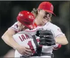  ?? — GETTY IMAGES ?? Jered Weaver hugs catcher Chris Iannetta as he celebrates his no-hitter.