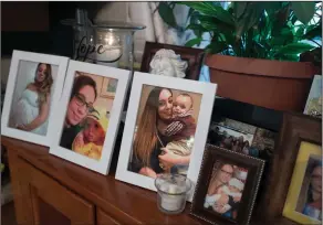  ?? Mark Lennihan/AP ?? Science: Chelsea Cobo holds her son, Christophe­r, in framed photos arranged as a shrine at her home in the Brooklyn borough of New York. Cobo disappeare­d in May of 2016. New DNA science developed to identify the skeletal remains of the 9/11 dead now...