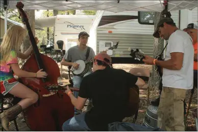  ?? Carolyn Grindrod /
Rome News-Tribune ?? Cassie Hicks (from left), 16, of Cedartown, plays upright bass with her brother Bryce Hicks of Cedartown on banjo alongside Jesse Slay (seated) of Buchanan on guitar and his father Matt Slay of Buchanan on mandolin.