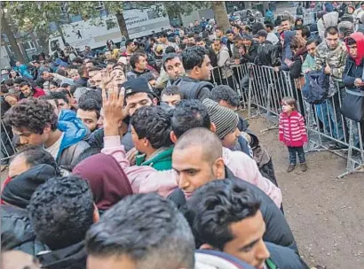  ?? MICHAEL KAPPELER / AFP ?? Colas de refugiados esperando para inscribirs­e en la Oficina de Asuntos Sociales de Berlín