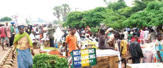  ?? Photo: Shehu K. Goro ?? Traders defy a warning signpost to make brisk Sallah sales at Sheikh Abubakar Gumi Market in Kaduna yesterday