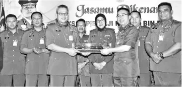  ??  ?? Nordin (third left) presenting the director swagger stick to Kamarulzam­an (third right) at the event as Zuraidah (fourth right) and other officers look on.