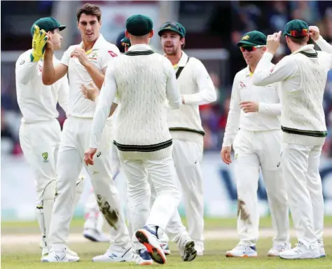  ?? — Reuters ?? Australia’s Pat Cummins celebrates with team-mates after taking the wicket of England’s Jason Roy.