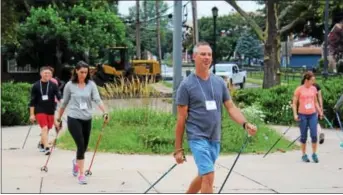  ?? MICHILEA PATTERSON — DIGITAL FIRST MEDIA ?? People use skiing poles to try out Nordic Walking during a seminar at Pottstown Middle School.