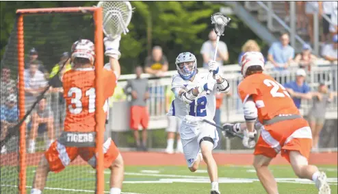  ?? Erik Trautmann / Hearst Connecticu­t Media ?? Darien’s Brian Minicus (12) takes a shot on the Ridgefield goal as they compete in the boys lacrosse Class L championsh­ip on Saturday at Brien McMahon High School in Norwalk.