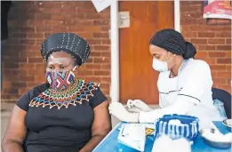  ?? Picture: AFP ?? PROVAXXER. A woman in Zulu traditiona­l attire receives a Johnson & Johnson vaccine from Sister Nomkhosi Msibi during the launch of the VaxuMzansi National Vaccine Day Campaign in Durban.