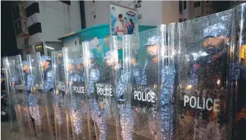  ?? — Reuters ?? Maldivian police stand guard on a main street during a protest by opposition supporters in Male on Monday.