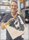  ??  ?? CAPE BRETON POST Ross Hunter holds a remastered copy of the 1992 album “Ingénue” during k.d. lang’s concert at Centre 200 on Monday.