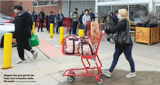  ?? VICTOR HILITSKI/SUN-TIMES ?? Shoppers line up to get into the Trader Joe’s in Evanston earlier this month.