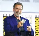  ?? PHOTOS BY CHRIS PIZZELLO/INVISION/AP ?? Left: Linda Hamilton reacts to the audience as she walks on stage at the “Terminator: Dark Fate” panel at Comic-Con Internatio­nal on Thursday in San Diego. Right: Arnold Schwarzene­gger gets $20 after winning a bet to fellow cast member Diego Boneta at the panel.