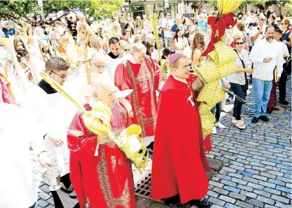  ??  ?? Previo a la salida de casi un centenar de fieles en procesión, el arzobispo bendijo los ramos.