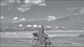  ??  ?? A monk cycling in Western Sichuan in the Kham region of Tibet.