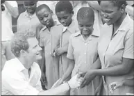  ?? (AFP) ?? Britain’s Prince Harry greets pupils at a primary school for blind children on Feb 27, in Maseru. The prince visited his charity projects in Lesotho, finding time to perform traditiona­l dance moves with children during his return visit to the southern...