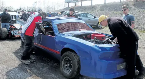  ?? PHOTOS BY BERND FRANKE/POSTMEDIA NETWORK ?? Race cars are inspected in the parking lot at Merrittvil­le Speedway in Thorold giving the pit area a chance to dry out at Saturday's test and tune session.