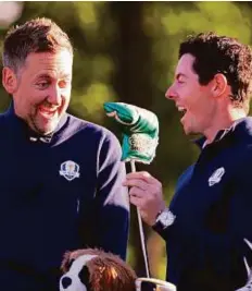  ?? AP ?? Ian Poulter shares a laugh with McIlroy before a practice round for the Ryder Cup yesterday.