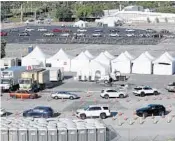  ?? WILFREDO LEE/AP ?? Cars line up at a drive-thru coronaviru­s testing site in front of Hard Rock Stadium on March 30 in Miami Gardens.