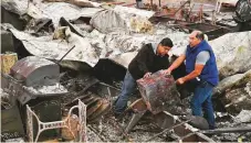  ?? AP ?? Santos Alvarado and his son Ricky recover a safe deposit box from their destroyed home at Seminole Springs Mobile Home Park following devastatin­g wildfires in the area.