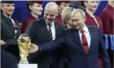  ?? ?? Vladimir Putin strokes the World Cup trophy while standing alongside Gianni Infanti- Dexamethas­one was the first steroid shown to be effective in severely ill Covid-19 patients. no, the FIFA President, after the 2018 World Cup final.