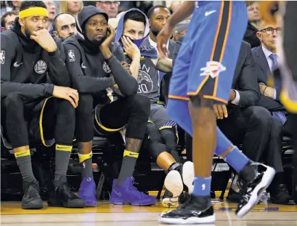  ?? Santiago Mejia / The Chronicle ?? JaVale McGee, Kevin Durant and Stephen Curry struggle to watch the end of the Warriors’ loss at Oracle Arena.