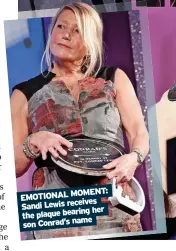  ?? ?? MOMENT: EMOTIONAL receives Sandi Lewis her the plaque bearing name son Conrad’s