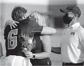  ?? [SARAH PHIPPS/ THE OKLAHOMAN] ?? McGuinness' Drew Schomas hugs his mom before playing Muskogee on Senior Night at McGuinness last Friday.