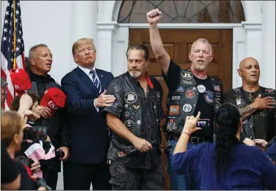  ?? AP/CAROLYN KASTER ?? President Donald Trump joins motorcycli­sts to recite the Pledge of Allegiance in the rain at a “Bikers for Trump” event Saturday at his golf resort in Bedminster, N.J.