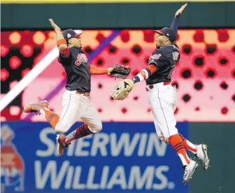  ??  ?? Indians teammates Francisco Lindor, left, and Rajai Davis celebrate after Game 1 against the Cubs on Tuesday in Cleveland. The Indians won 6-0.