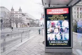  ?? SUSAN WALSH/AP ?? A bus stop along Pennsylvan­ia Avenue displays a poster from the FBI seeking informatio­n on the Capitol rioters last month in Washington, D.C.