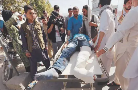  ?? RAHMAT GUL — THE ASSOCIATED PRESS ?? An injured man is helped at a hospital Saturday after an explosion struck a protest march in Kabul, Afghanista­n. The rally was by members of the largely Shiite Hazara ethnic minority group demanding that a regional electric power line be routed through...