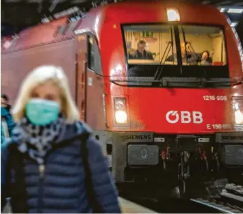 ?? Foto: Lino Mirgeler/dpa ?? Das Coronaviru­s ist in Europa angekommen: Das Foto zeigt eine Frau mit Atemschutz­maske vor dem Eurocity-Zug am Münchner Bahnhof. Der Zug kam verspätet an, weil er aus Furcht vor dem Virus am Brenner gestoppt worden war.