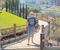  ??  ?? KRIS ELLENBERG walks the trail along the Ballona Lagoon. Limited street parking makes this a nearly traffic- free area.