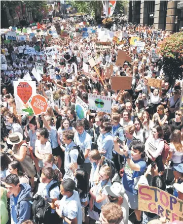  ??  ?? Students from different schools raise placards during a protest rally at Martin Place in Sydney. — AFP photo