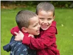  ?? DANA JENSEN/THE DAY ?? Cayden Torres, 6, right, gives his twin brother, Carter, of Norwich a hug Thursday in their backyard. The boys were diagnosed with retinoblas­toma, a cancer in their eyes, and are doing well.