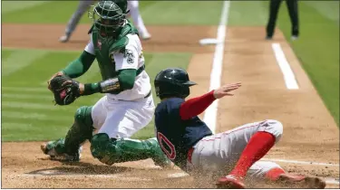  ?? AP FILE ?? SLIDE TO SAFETY: Boston Red Sox designated hitter Jarren Duran, front right, slides into home ahead of the relay to Oakland Athletics catcher Christian Bethancour­t, left, on during the first inning of a baseball game on June 5 in Oakland, Calif.