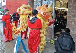  ?? Photos by Kirk Barron/ Appeal-Democrat ?? Lion Dancers shred a head of lettuce in front of Upper Cut Barbershop on Third Street during the 136th annual Bok Kai Festival on Saturday in Marysville.