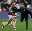  ??  ?? Mark Noble tackles a pitch-invader