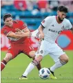  ?? ICON SPORTSWIRE GETTY IMAGES ?? Chicago Fire midfielder Brandt Bronico grabs the shirt of TFC midfielder Jonathan Osorio as they battle for the ball in Bridgeview, Ill., on Saturday. TFC halted a six-game MLS slump.